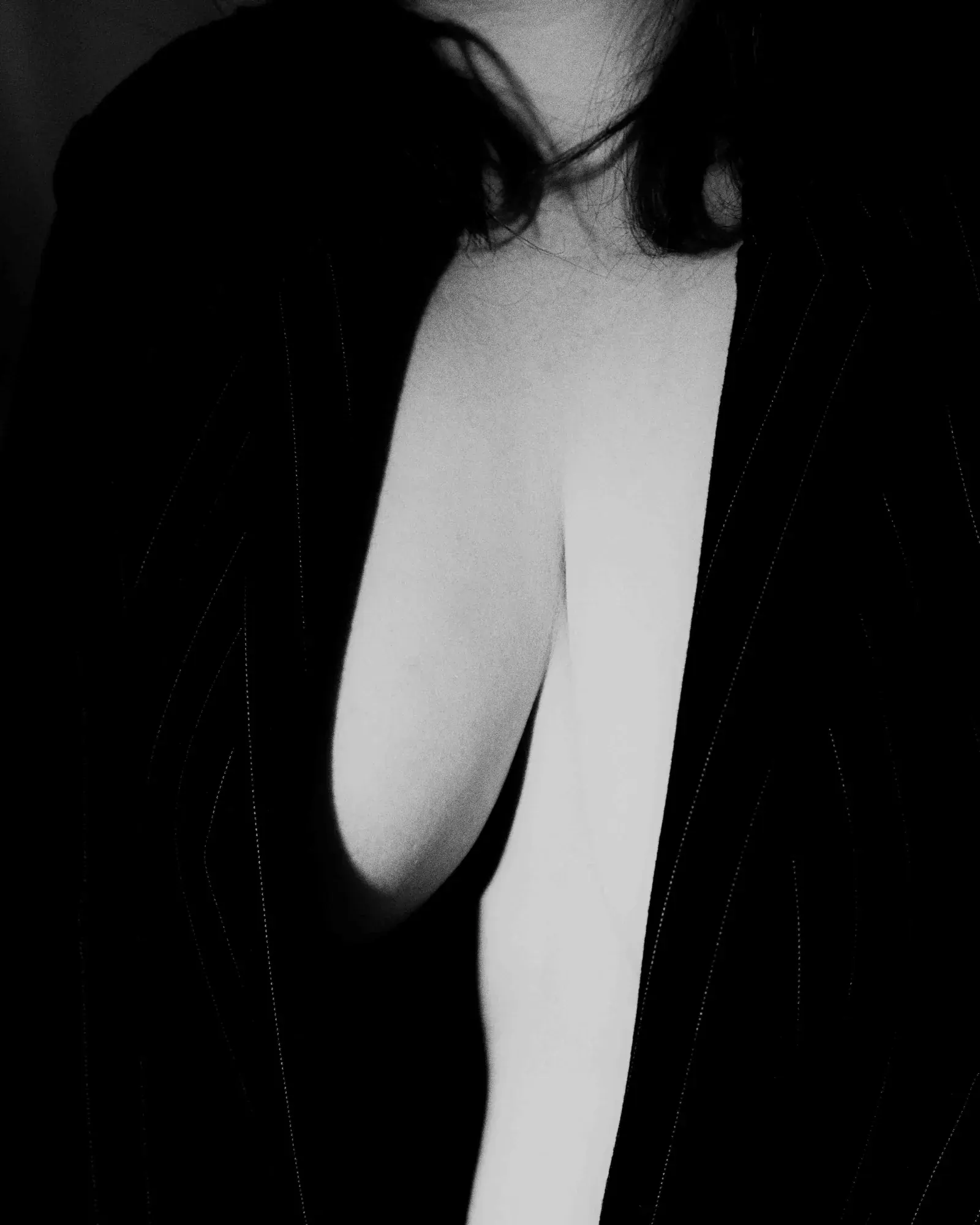 Retrato en blanco y negro con saco negro y escote pronunciado, fotografía boudoir CDMX